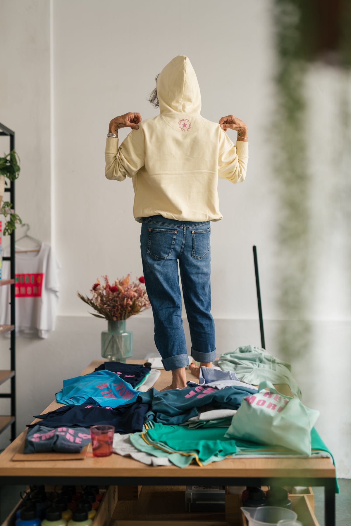 Rückansicht des MORE AMORE Boxy Hoodies in Soft Yellow mit pinkem Nackenprint