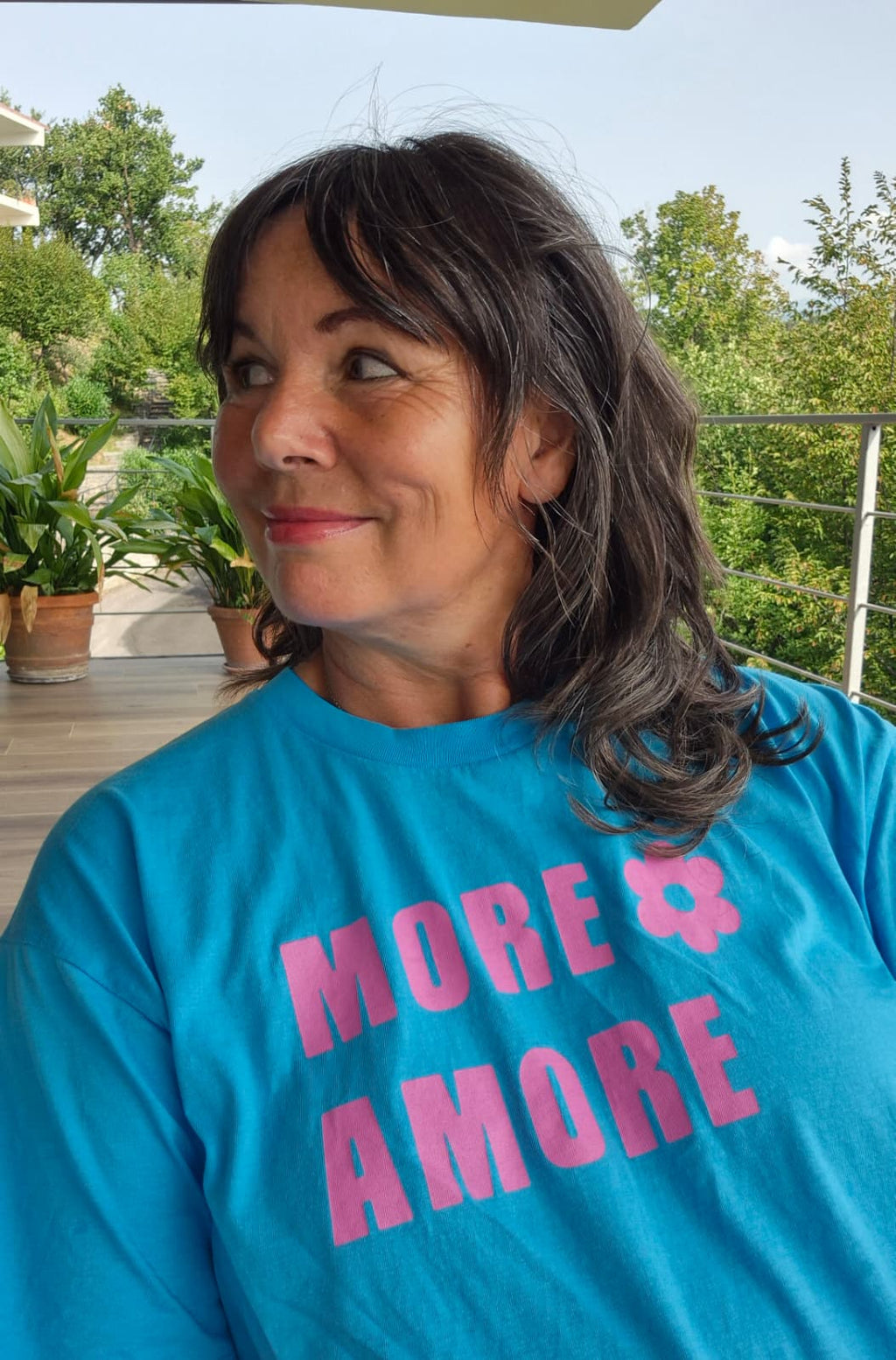 SUSANNE trägt das MORE AMORE Cropped T-Shirt in Aqua Blue mit Purple Print
