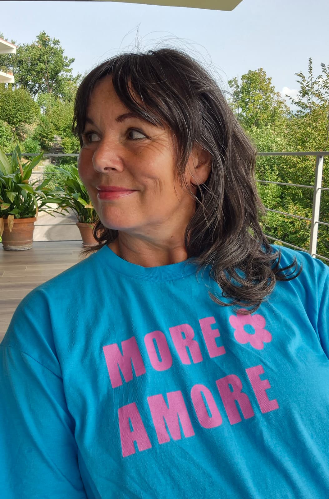 SUSANNE trägt das MORE AMORE Cropped T-Shirt in Aqua Blue mit Purple Print