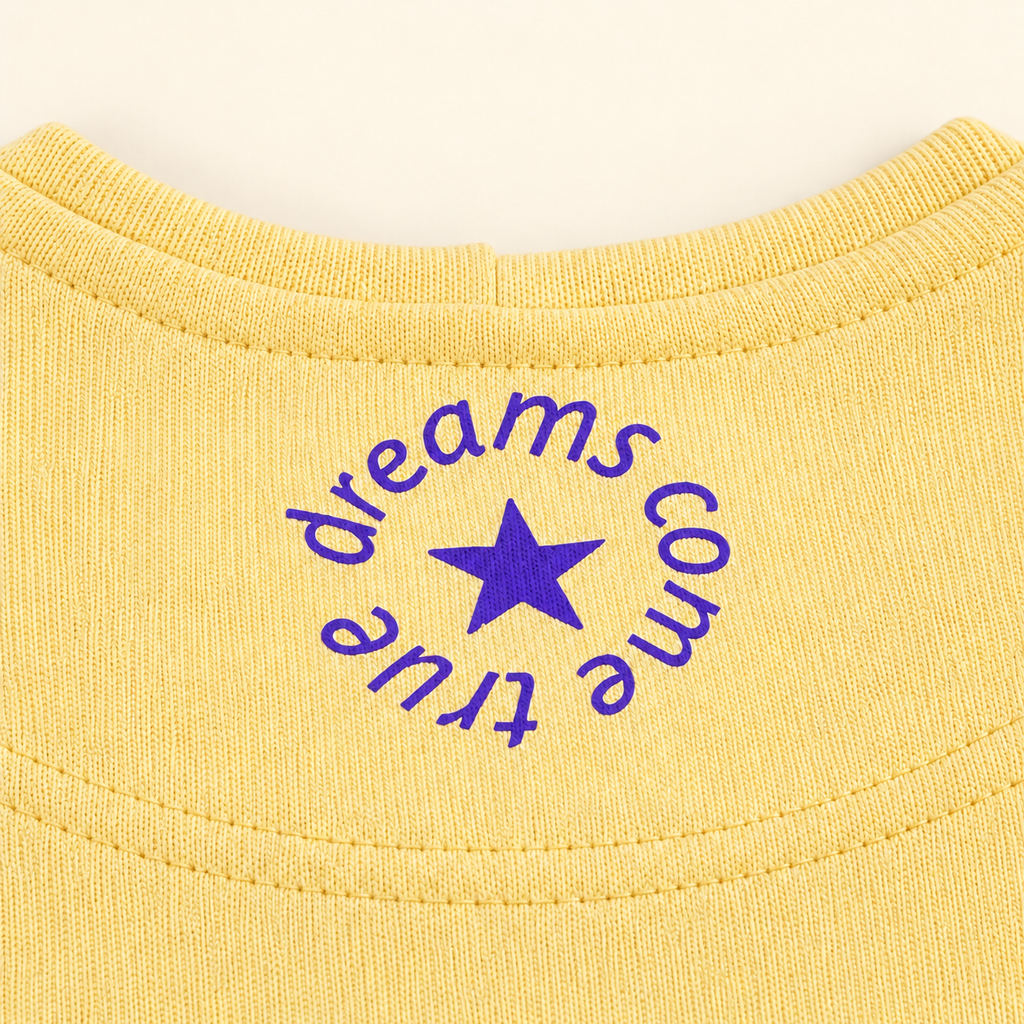 MORE AMORE Boxy Unisex-Hoodie in Soft Yellow – Detail des violetten Nackenprints mit Stern