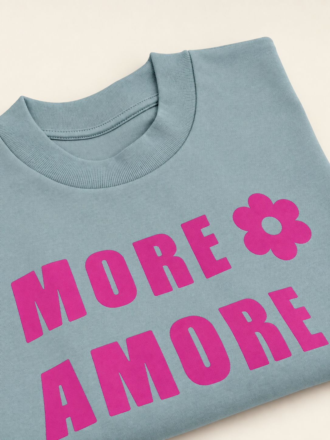 Detailansicht des pinken MORE AMORE Prints auf Dusty Blue